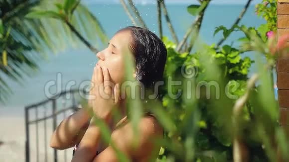 美丽的年轻女子在户外淋浴性感和性感在暑假时会缓慢地洗头视频的预览图