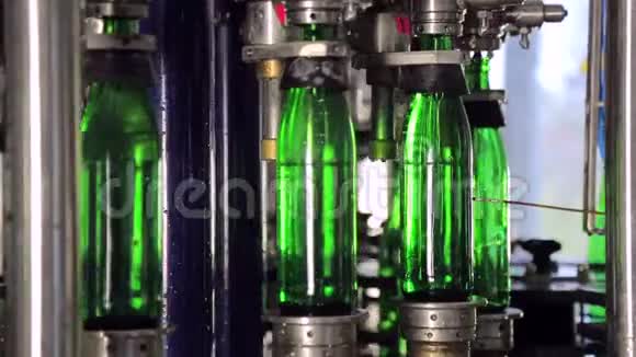 线的制水绿色玻璃瓶沿着生产线自动移动并装满水视频的预览图
