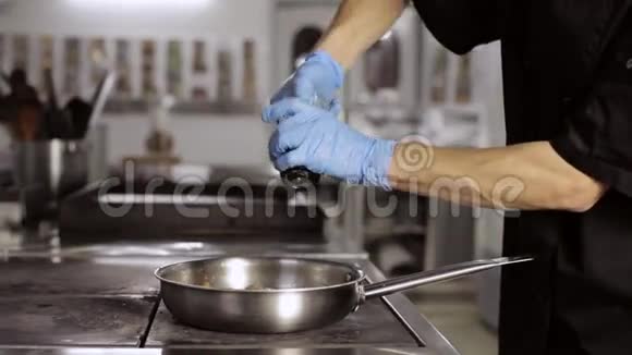 专业厨师在煎锅上的蔬菜中加入胡椒视频的预览图