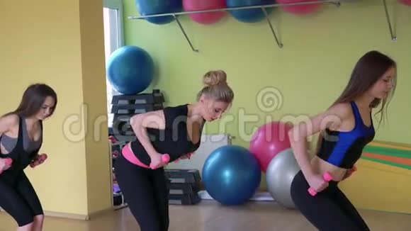 在健身房用哑铃锻炼的女性团体4k视频的预览图