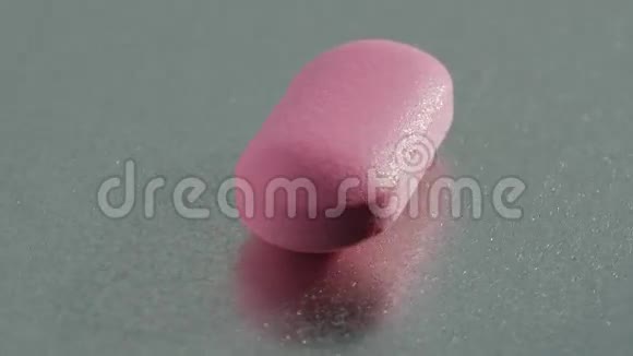 粉红色的药丸在金属表面旋转视频的预览图