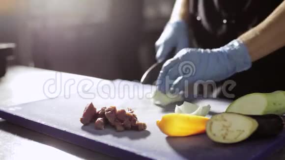 厨师手戴手套在商业厨房切洋葱视频的预览图