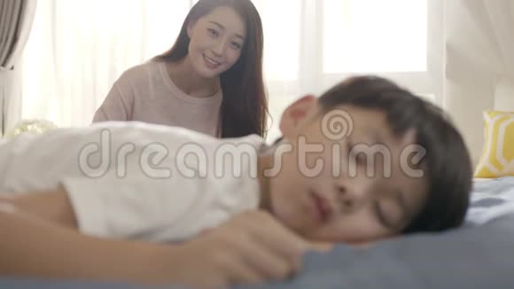 接近年轻的亚洲母亲微笑早上醒来她的儿子视频的预览图