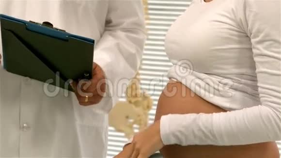 医生给他怀孕的病人看他的笔记视频的预览图