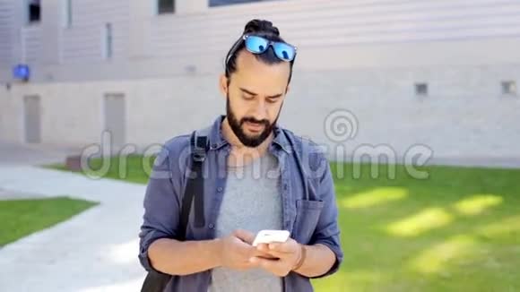 47岁的男子背着背包在智能手机上发短信视频的预览图