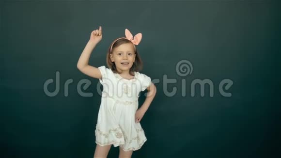 可爱快乐的小女孩跳舞在绿色背景上微笑的儿童肖像视频的预览图