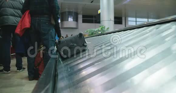 从机场传送带上收集行李的乘客视频的预览图