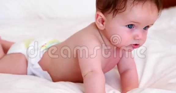 婴儿穿着尿布在床上爬行视频的预览图