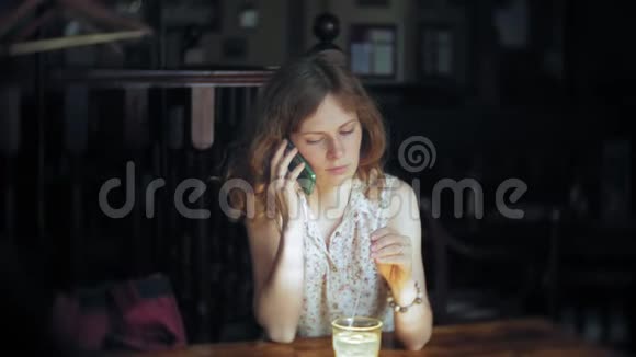 一个女人在餐馆喝鸡尾酒用电话视频的预览图