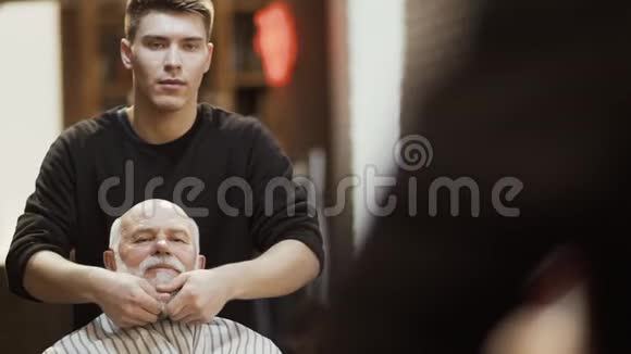 理发师为理发店的成熟男人做时尚的胡须视频的预览图