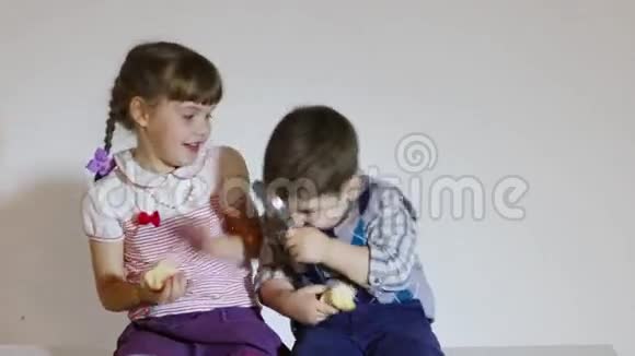 特写小女孩和男孩吃苹果和玩百叶窗视频的预览图