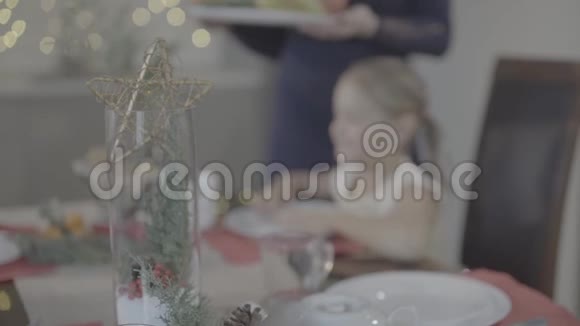 爱的母亲亲吻幸福可爱兴奋的宝贝女儿脸颊节日厨房圣诞晚餐装饰视频的预览图