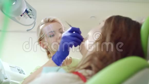 口腔科专家在牙科办公室与病人合作牙齿治疗视频的预览图