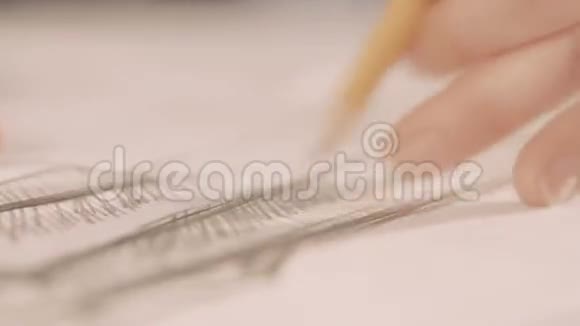 双手用铅笔画画时装设计师在工作室画画关门视频的预览图