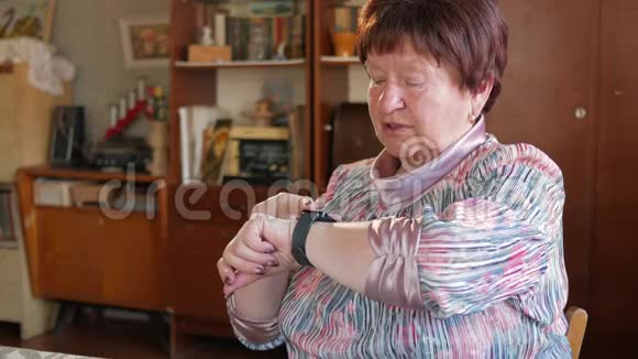 一位老年妇女在智能手表上检查信息她读提醒并说出搜索的短语之后视频的预览图