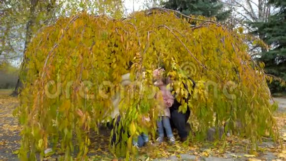 秋天幸福的一家人在公园散步父母和两个孩子视频的预览图