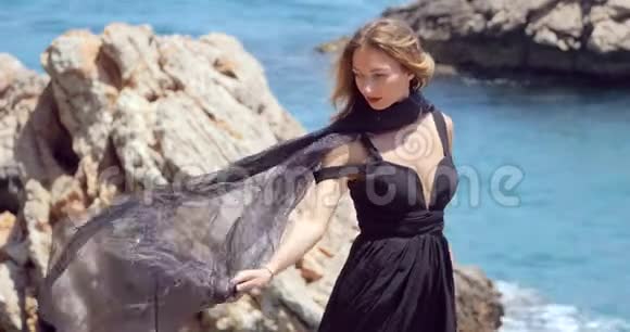 美丽的女人戴着黑色的围巾穿着优雅的黑色衣服视频的预览图