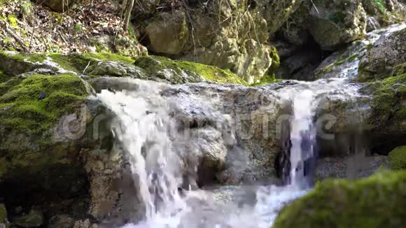 小山河上的瀑布急流在长满青苔的石质河床中流淌春天纯净的淡水视频的预览图