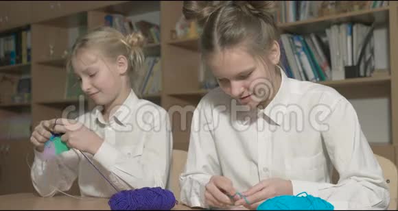 两个女孩在教室或房间里学习编织视频的预览图