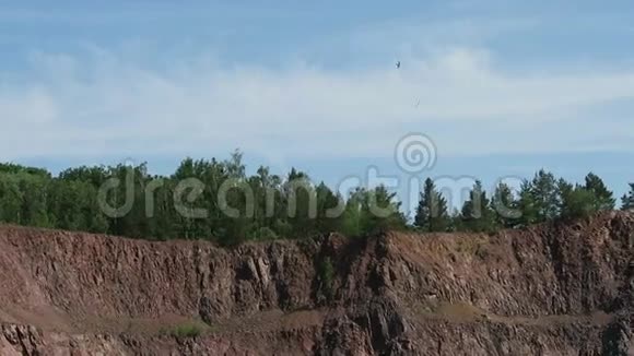 在露天矿采石场上空飞行的科鸟类斑岩相机锅工业的再性质视频的预览图