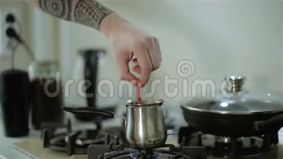 有纹身的男人用勺子搅拌咖啡视频的预览图