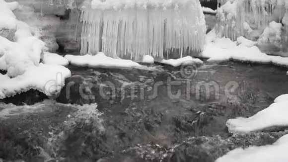 森林中带河的雪冬景观流动的水和破冰视频的预览图