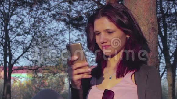 有魅力的年轻女子在手机上打字视频的预览图