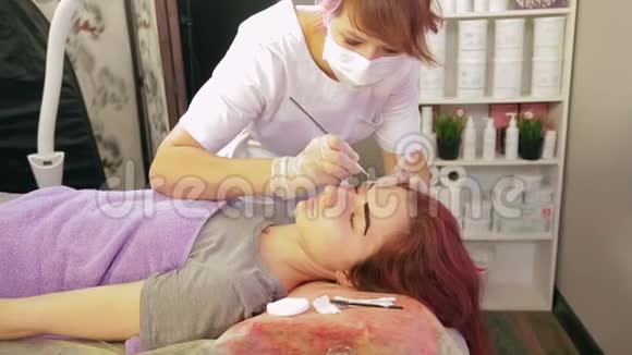 美容师用特殊的刷子用眉毛画客户视频的预览图