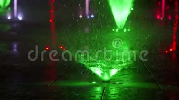 夜晚五彩缤纷的舞蹈喷泉在黑暗背景下缓慢运动的水喷流特写镜头无法辨认视频的预览图