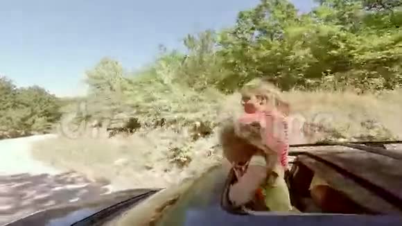 两个微笑着的年轻金发女郎正挥手离开一辆汽车的舱门向森林走去视频的预览图