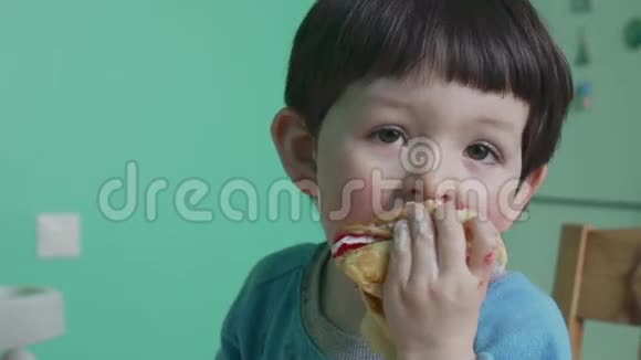 有趣的小男孩在家吃奶油煎饼视频的预览图