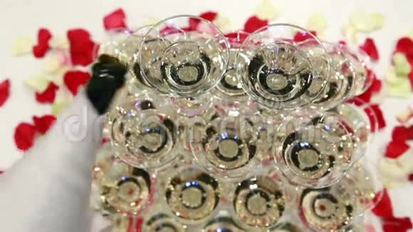 侍者在玻璃塔上倒香槟花瓣背景呈上升趋势视频的预览图