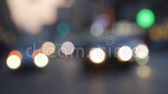 汽车和步行的人在城市的街道上夜晚模糊的背景视频的预览图