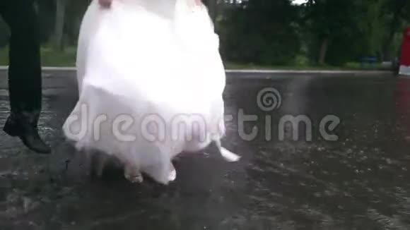在雨中举行婚礼新娘和新郎在雨中跳跃洗澡视频的预览图