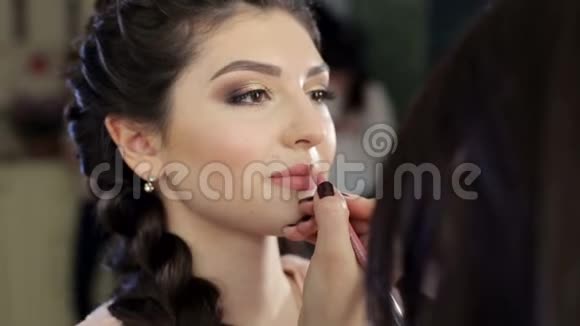 化妆师描绘了年轻女孩的嘴唇视频的预览图