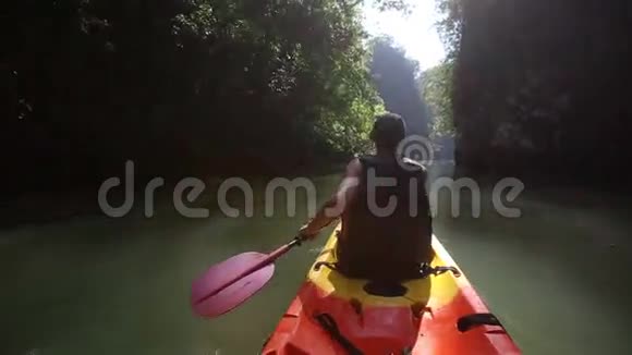 老人沿着阳光明媚的峡谷漂流在河边的皮艇上视频的预览图