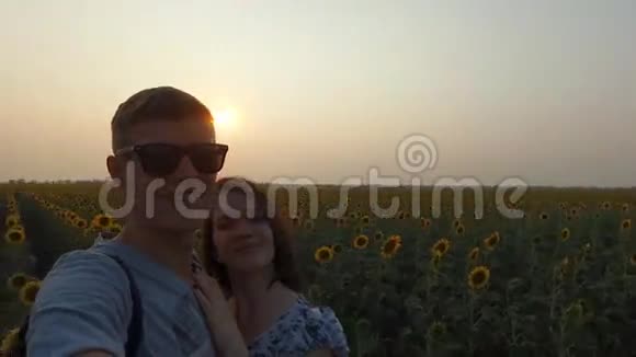 一对夫妇在向日葵的田野里接吻视频的预览图