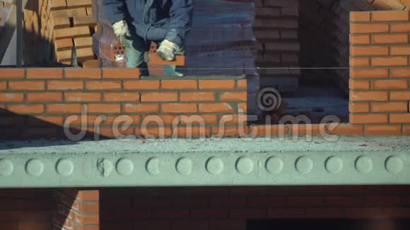 工人砌一堵砖墙建筑物上的建筑工人进行砌砖建筑工地的建筑工人视频的预览图