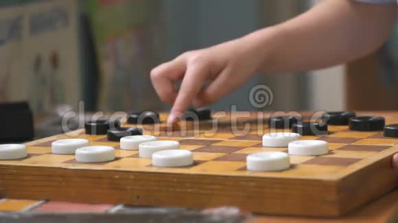 小男孩在花园里玩跳棋视频的预览图