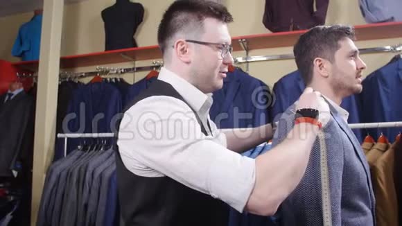 男士套装概念卖方帮助买方在服装店挑选一套衣服视频的预览图
