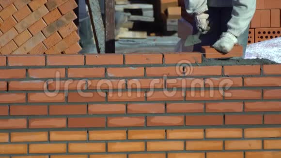 工人砌一堵砖墙建筑物上的建筑工人进行砌砖建筑工地的建筑工人视频的预览图