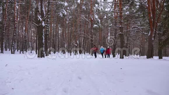 快乐的孩子和爸爸妈妈和孩子们一起在冬天的森林里跑步父母在雪地公园里玩孩子视频的预览图
