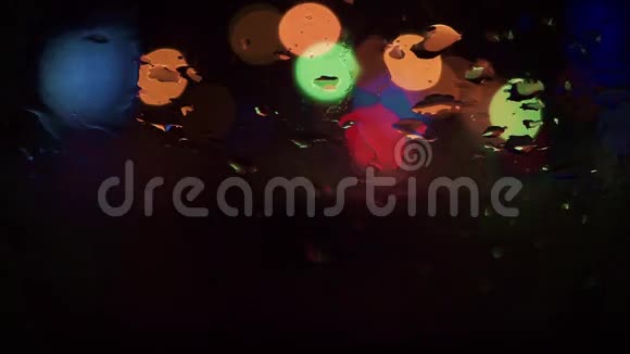 抽象的夜晚街道波克圈和雨滴在风幕上视频的预览图
