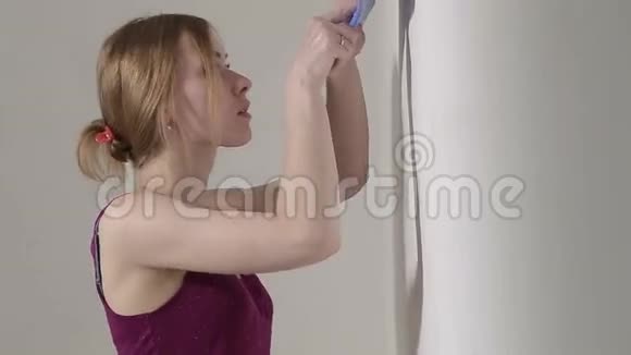 小女孩在家里用铲子抹灰墙壁视频的预览图