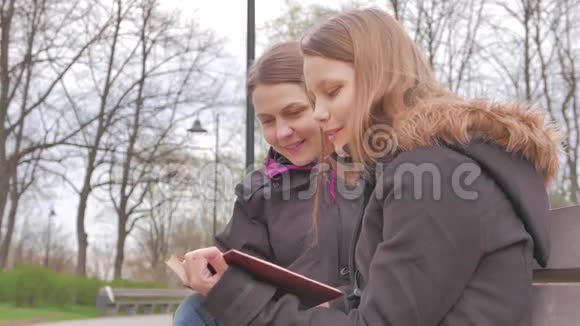 母女俩在公园里看书聊天4UHDK视频的预览图