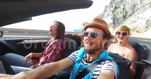 与朋友在蜿蜒曲折的高速公路上开敞篷车的大胡子男视频的预览图