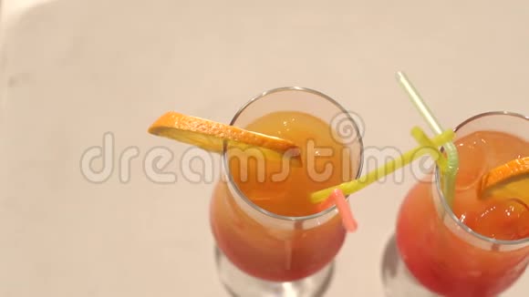用冰和稻草特写两杯橙汁视频的预览图