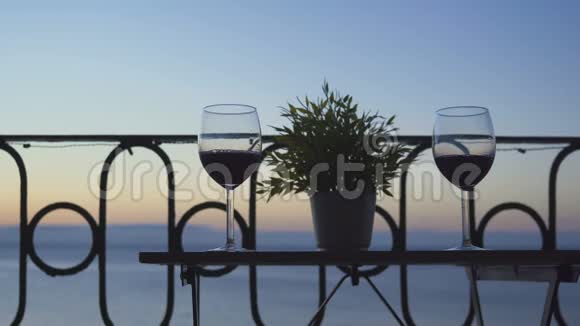 一男一女坐在阳台上在大海的背景上喝着红酒特写镜头视频的预览图