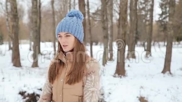 美丽的女孩在冬天公园揉手视频的预览图