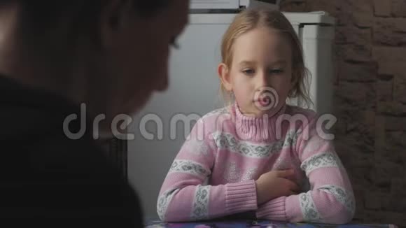 一个小女孩正在桌旁喝茶视频的预览图